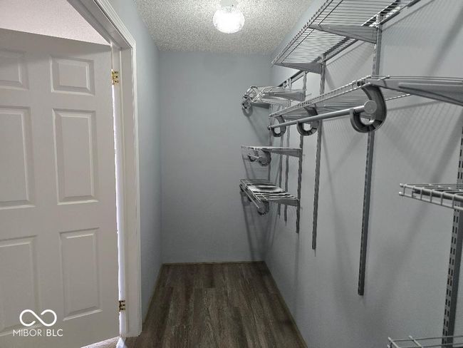 spacious closet with dark wood-style flooring | Image 25