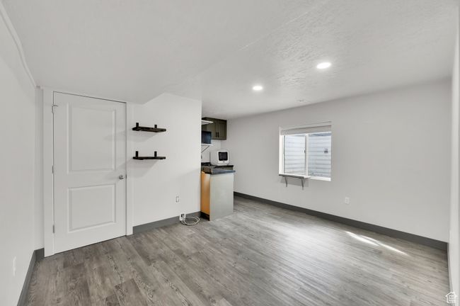 Unfurnished living room with baseboards, a textured ceiling, wood finished floors, and recessed lighting | Image 22