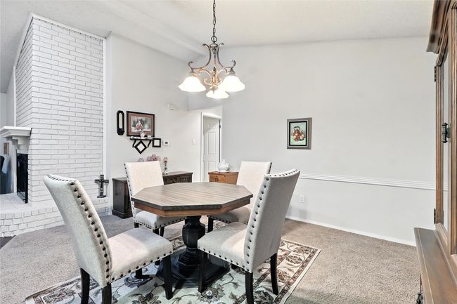 Carpeted dining room featuring a chandelier, high vaulted ceiling, and a fireplace | Image 18