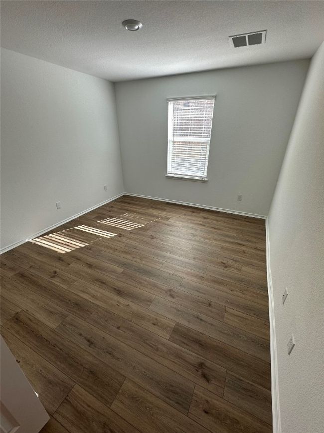 Empty room with baseboards, dark wood finished floors, and visible vents | Image 21
