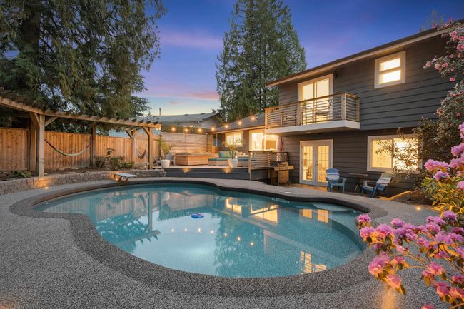 Pool at dusk featuring french doors, a fenced backyard, a diving board, and a pergola | Image 7