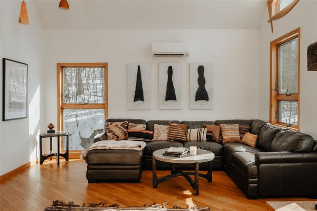 Living room with a wall mounted AC and light hardwood / wood-style floors | Image 9