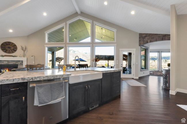 Kitchen with beamed ceiling, stainless steel dishwasher, dark wood-type flooring, a sink, and dark cabinetry | Image 13