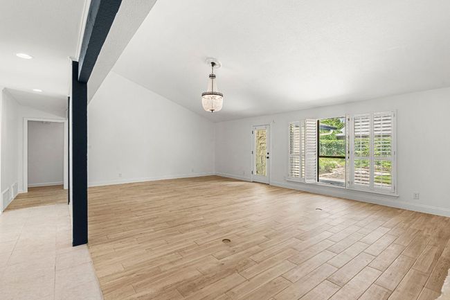 Unfurnished living room with light wood-style flooring, vaulted ceiling, and recessed lighting | Image 9