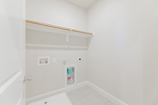 Laundry area featuring hookup for a gas dryer, electric dryer hookup, hookup for a washing machine, and light tile patterned flooring | Image 20