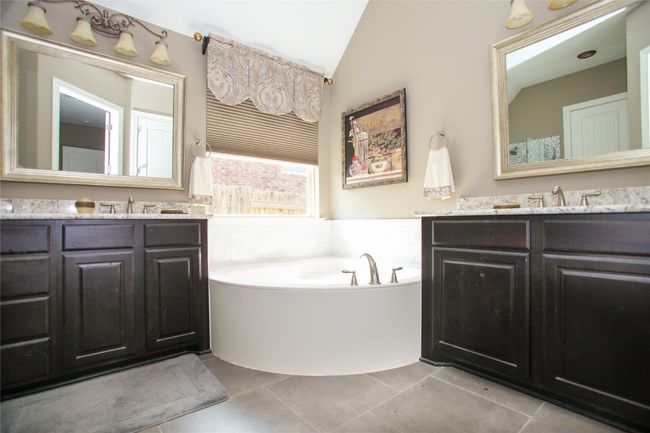 Bathroom with lofted ceiling, vanity, a bath, and tile patterned floors | Image 20