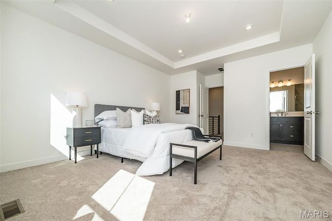 Bedroom featuring a raised ceiling, light carpet, connected bathroom, and recessed lighting | Image 23