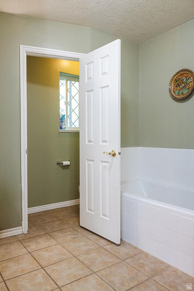 Bathroom featuring a garden tub, tile patterned flooring, and a textured ceiling | Image 17