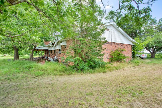 View of home's exterior featuring brick siding and a lawn | Image 9