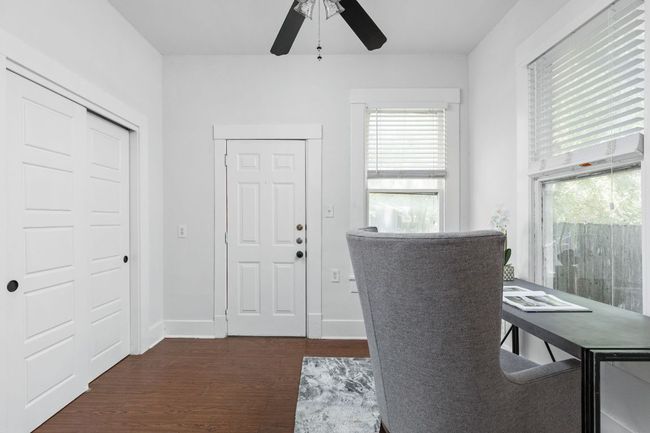 Office area with dark wood-style flooring, baseboards, and a ceiling fan | Image 17