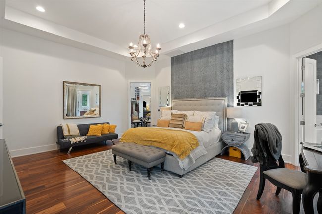Retreat to refined comfort in this serene owner’s sanctuary. This primary suite offers sophisticated design details, custom window treatments, and a walk-in closet with custom built-in cabinets and drawers, paired with under-shelf lighting for a boutique-like experience . | Image 8