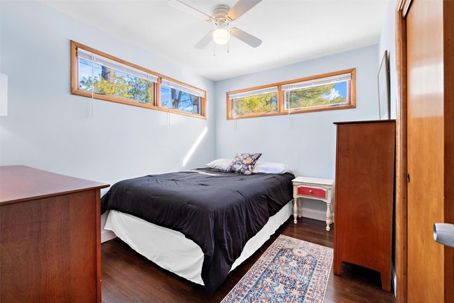 Bedroom featuring dark wood-style floors and ceiling fan | Image 29