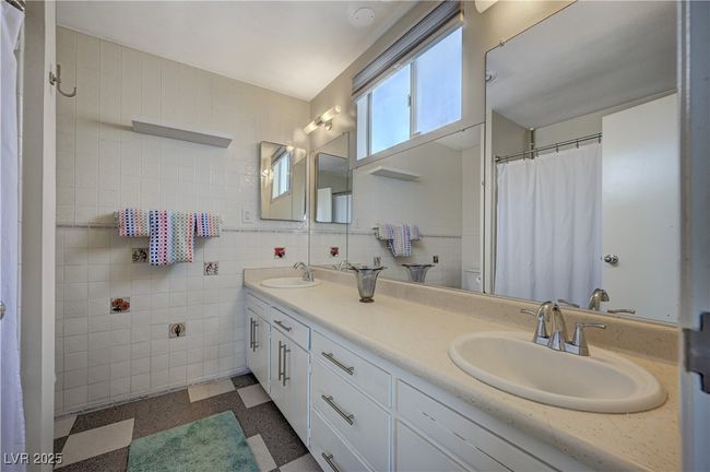 Bathroom featuring double vanity, a sink, tile walls, and tile patterned floors | Image 27