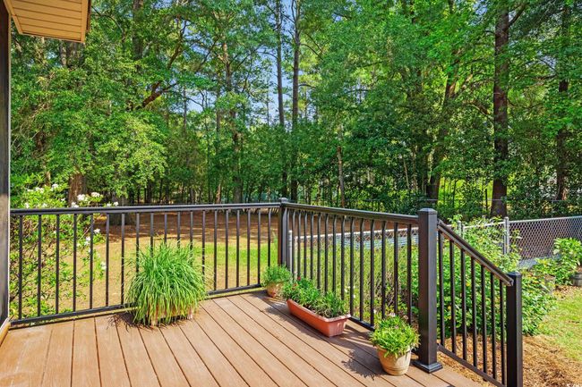 Wooden deck featuring view of wooded area | Image 24
