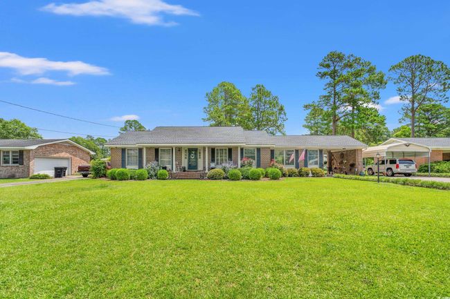 Ranch-style home featuring a porch, a front lawn, and brick siding | Image 24