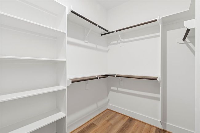 Featuring multiple hanging rods and integrated shelving, this well-designed closet makes it easy to keep everything in order. | Image 22
