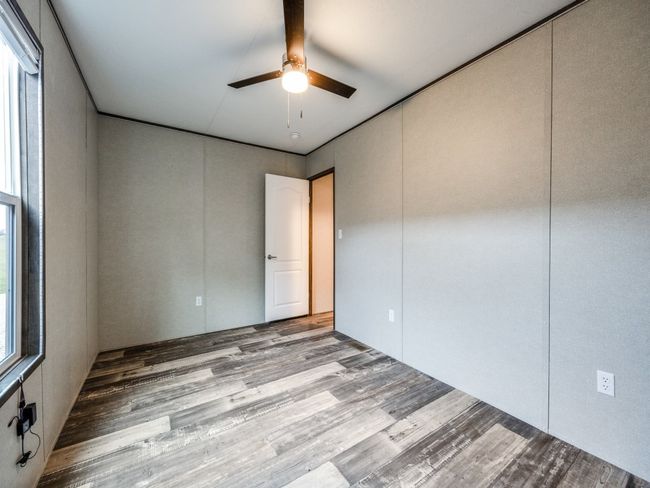 Empty room with ceiling fan and wood finished floors | Image 10