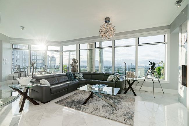Living area featuring a view of city, baseboards, crown molding, and a chandelier | Image 15