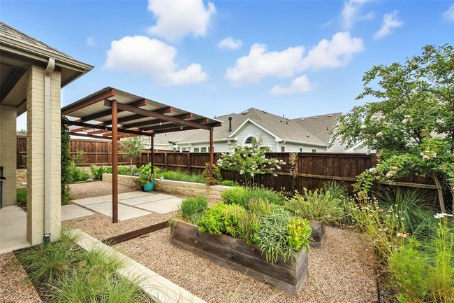 Fenced backyard with a patio area and a vegetable garden | Image 31