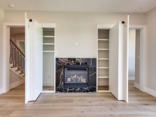 Living room built-in cabinets with doors open to access hidden storage | Image 18