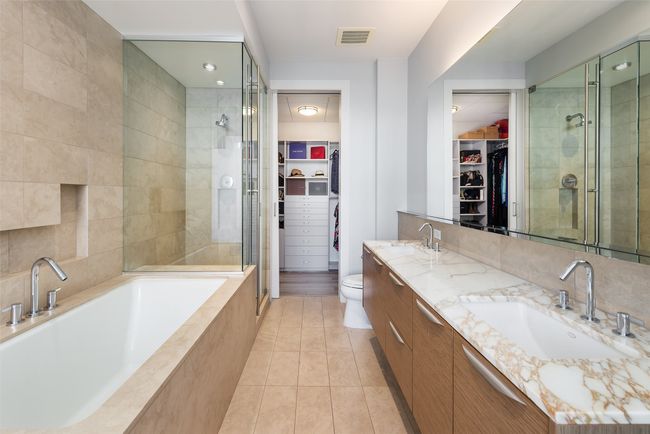 Primary bath has separate tub and shower, and custom closet finishes | Image 11