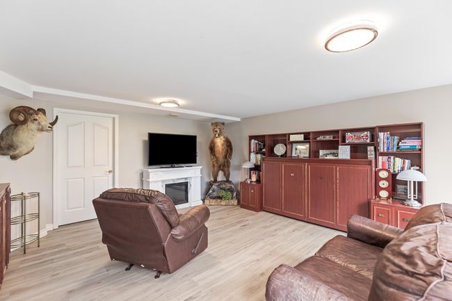 Living room with light wood-style flooring and a premium fireplace | Image 31