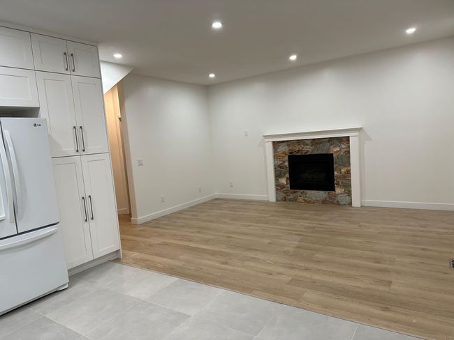 Unfurnished living room with a fireplace, recessed lighting, light wood-style flooring, and baseboards | Image 7