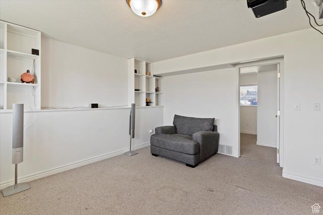 Living area with carpet, a textured ceiling, and baseboards | Image 21
