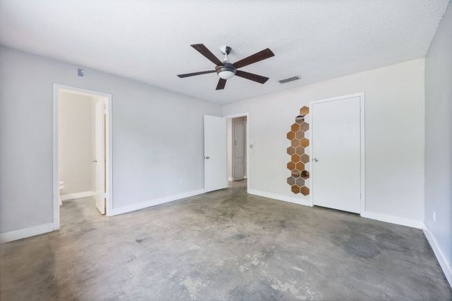 Spare room featuring concrete flooring, a ceiling fan, and a textured ceiling | Image 13