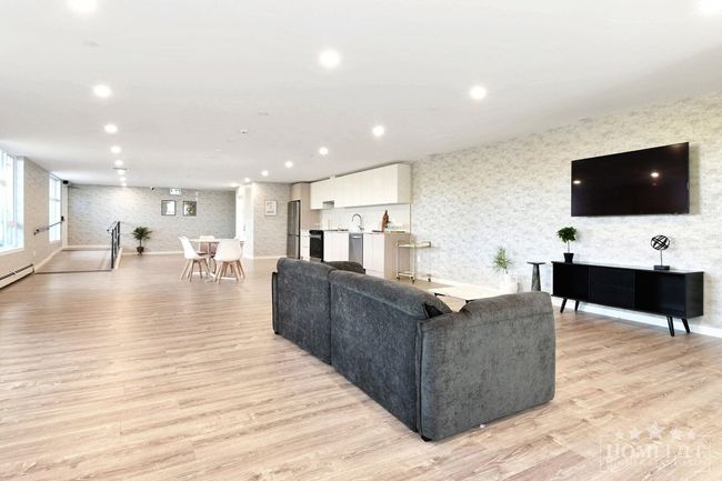 Living area featuring light wood-type flooring, wallpapered walls, and recessed lighting | Image 16