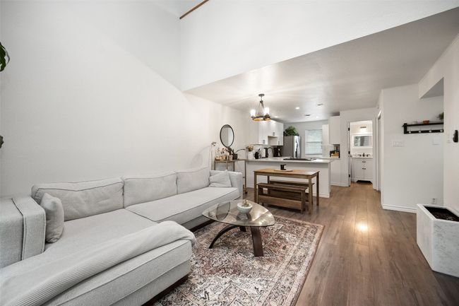 Open Concept Living Room with outdoor balcony and wood floors + vaulted ceilings. | Image 8