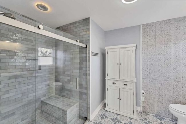Bathroom featuring a shower stall, tile patterned flooring, and toilet | Image 13