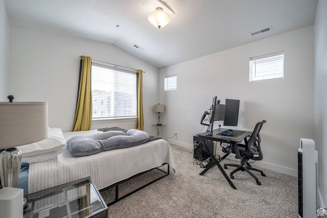 Carpeted bedroom featuring lofted ceiling, baseboards, and visible vents | Image 8