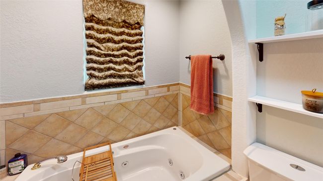 Full bathroom featuring a textured wall and a whirlpool tub | Image 27