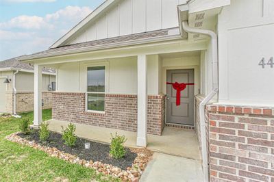 Behold the delightful farmhouse elevation of this 1649 square feet home. The exterior exudes a timeless appeal, with its classic design elements and a harmonious color palette. This house is sure to catch the eye of those seeking a blend of modern comfort and rustic charm. | Image 2