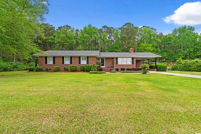 Single story home with a chimney, concrete driveway, a carport, brick siding, and a front yard | Image 22