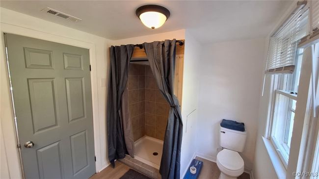 Bathroom featuring a shower stall, toilet, visible vents, and a wealth of natural light | Image 35