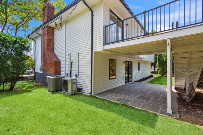 Rear view of property featuring a balcony, a yard, a chimney, and a patio | Image 36