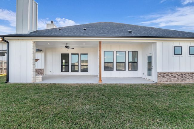 Large covered patio features a wood burning fireplace and patio door access to primary bedroom | Image 33