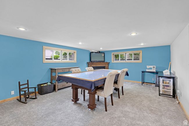 Dining room with light colored carpet, healthy amount of natural light, a fireplace, baseboards, and recessed lighting | Image 21