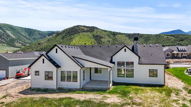 Back of property featuring a mountain view, a chimney, a patio, and roof with shingles | Image 32