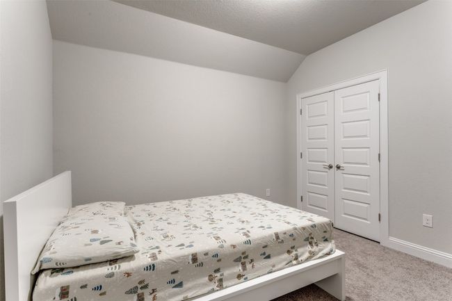 Bedroom featuring light colored carpet, vaulted ceiling, and a closet | Image 18