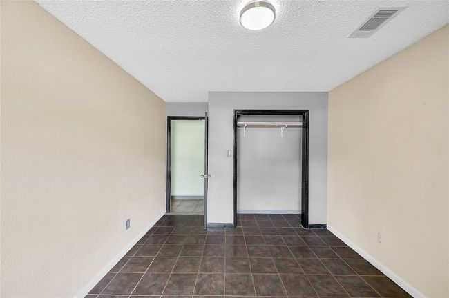 Cozy third bedroom with ample closet space and modern lighting, ideal for a guest room or home office. | Image 29