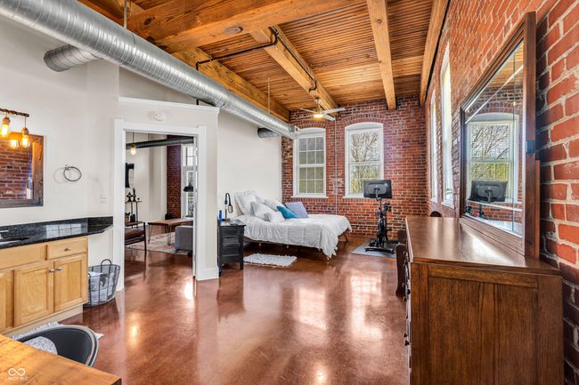 bedroom with brick wall, wooden ceiling, and beamed ceiling | Image 15