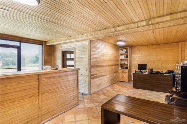Home office with wood ceiling, wood walls, and light tile patterned floors | Image 7