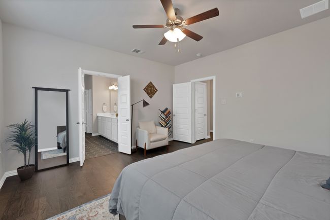 Bedroom featuring a ceiling fan, visible vents, baseboards, and dark wood finished floors | Image 20
