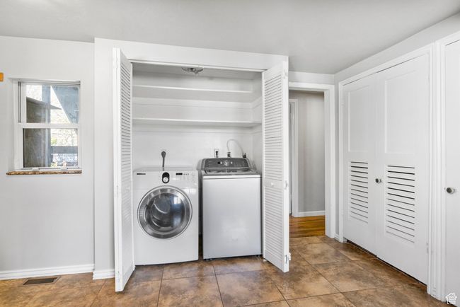 Washroom featuring laundry area, baseboards, visible vents, and washer and clothes dryer | Image 27