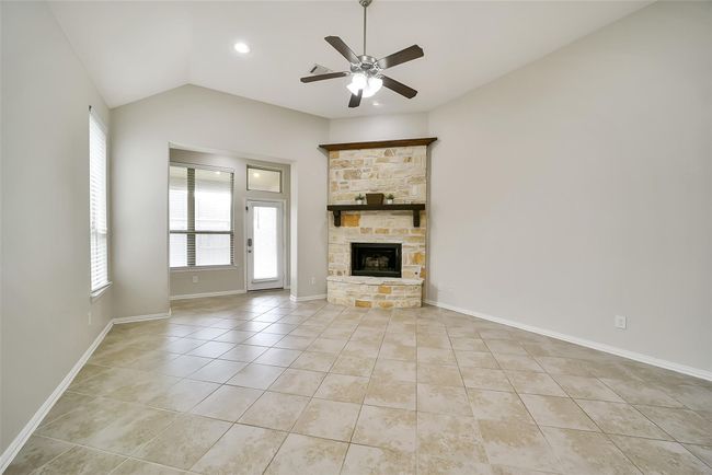 Your first view of the open-concept living room will immediately draw your eyes to the stone fireplace with rustic wood mantle. | Image 4
