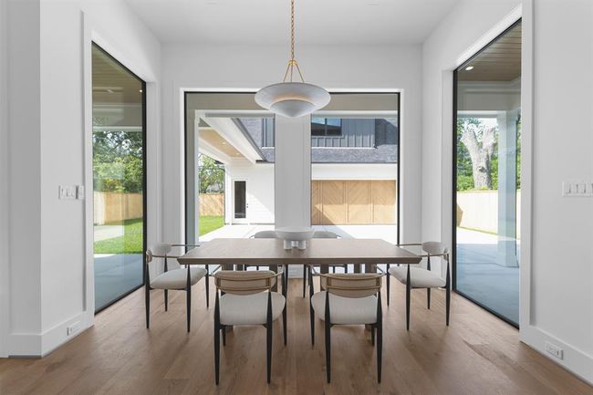 Bathed in natural light from expansive windows, the breakfast area offers a cozy yet refined space for casual dining. Nestled just off the kitchen, it features wide-plank white oak floors and a clean, open layout that invites relaxed mornings and effortless connection. | Image 19