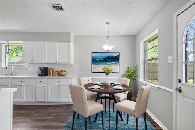 The dining area is bright and welcoming, with a large window that offers a picturesque view of the backyard. Its open design creates a perfect space for enjoying meals while soaking in natural light and serene outdoor scenery. | Image 11